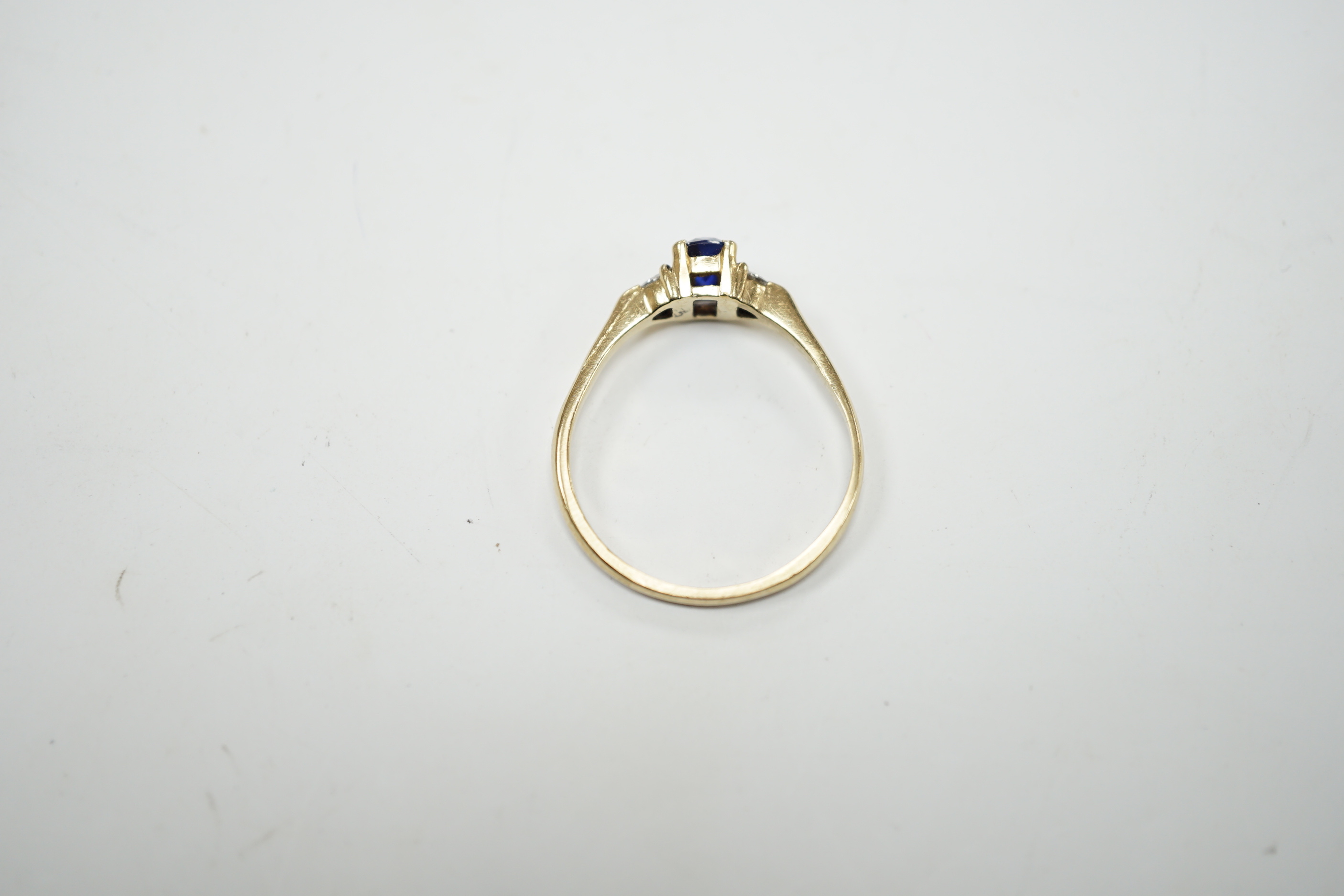 A yellow metal and single stone oval cut sapphire set ring, with two stone heart shaped diamond set shoulders, size U/V, gross weight 2.4 grams.